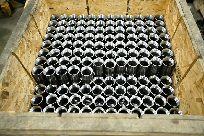 Crate of steel tube, with set screw hole, NPT tread, and window